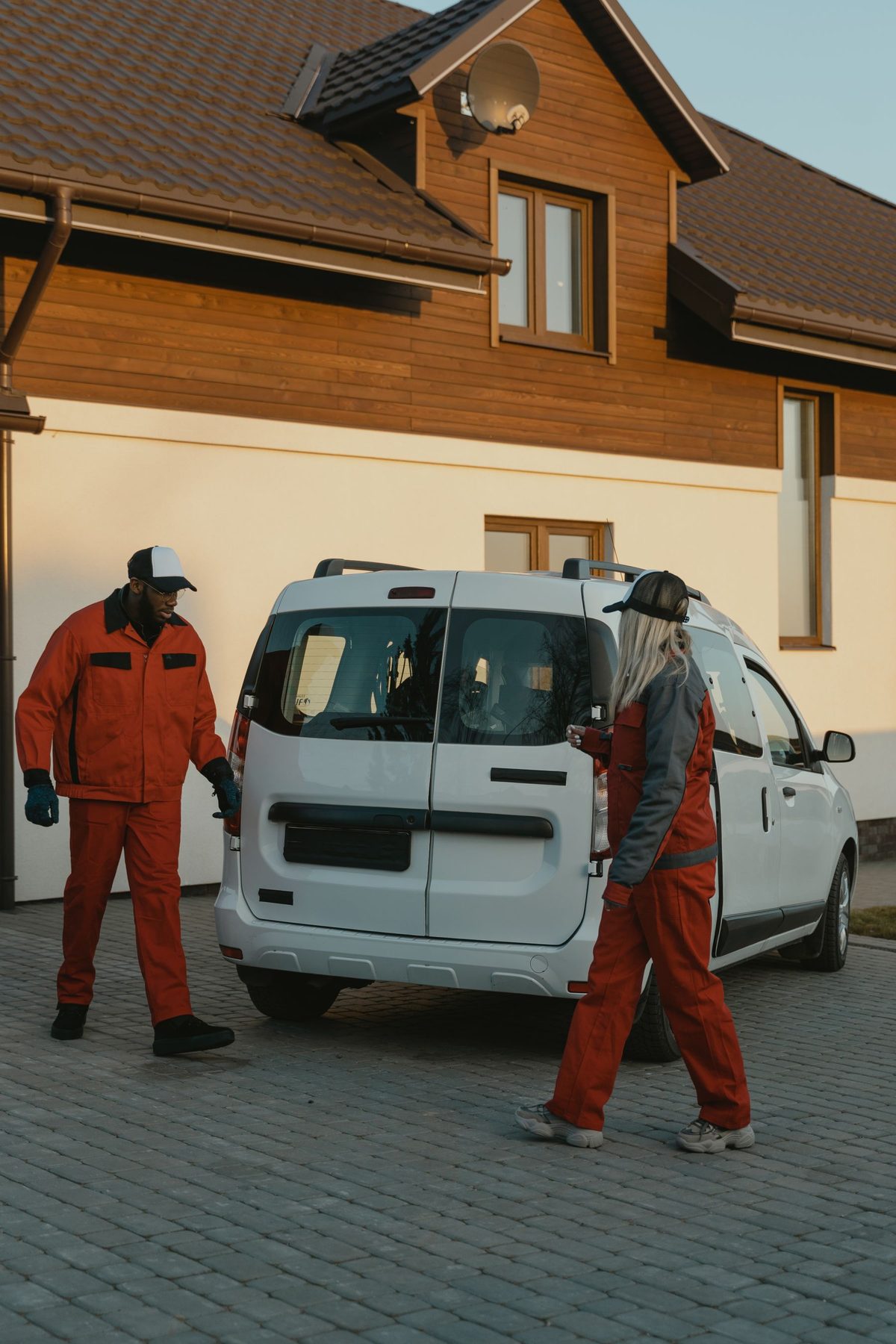 Home-service professionals beside a service van in a residential neighborhood