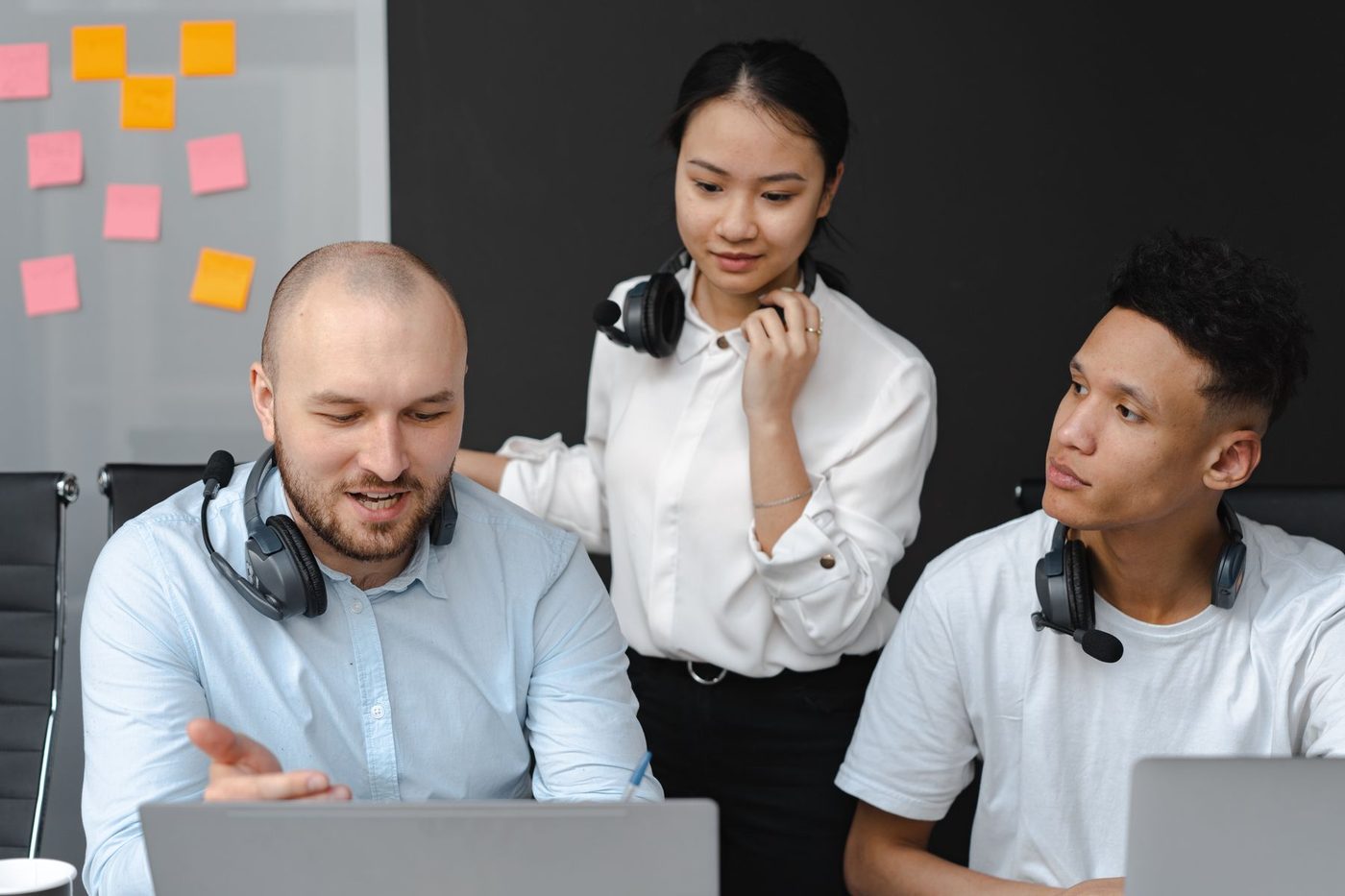 Customer service team collaborating around a laptop