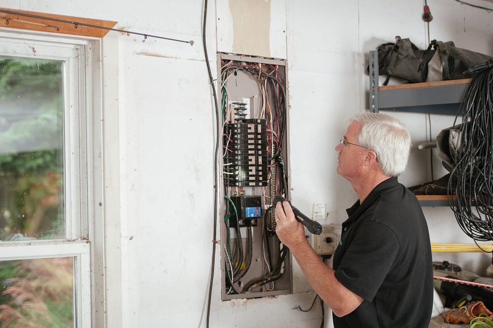 Electrician inspecting a residential electrical panel